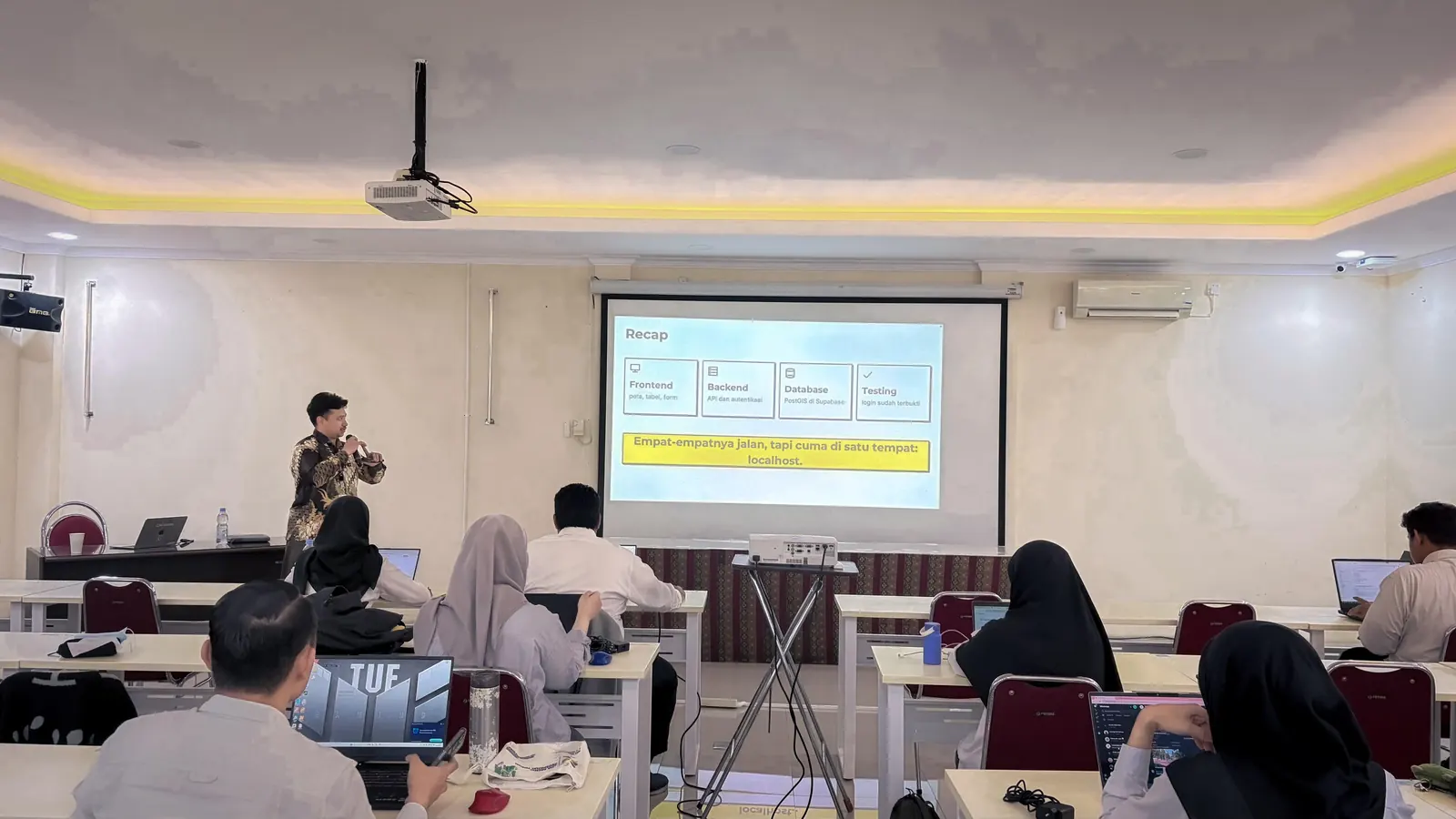 Dhany presenting a recap slide to participants in the training room
